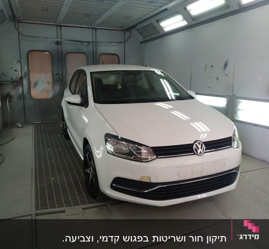 מכונית לבנה בתא צבע עם סימני תיקון
